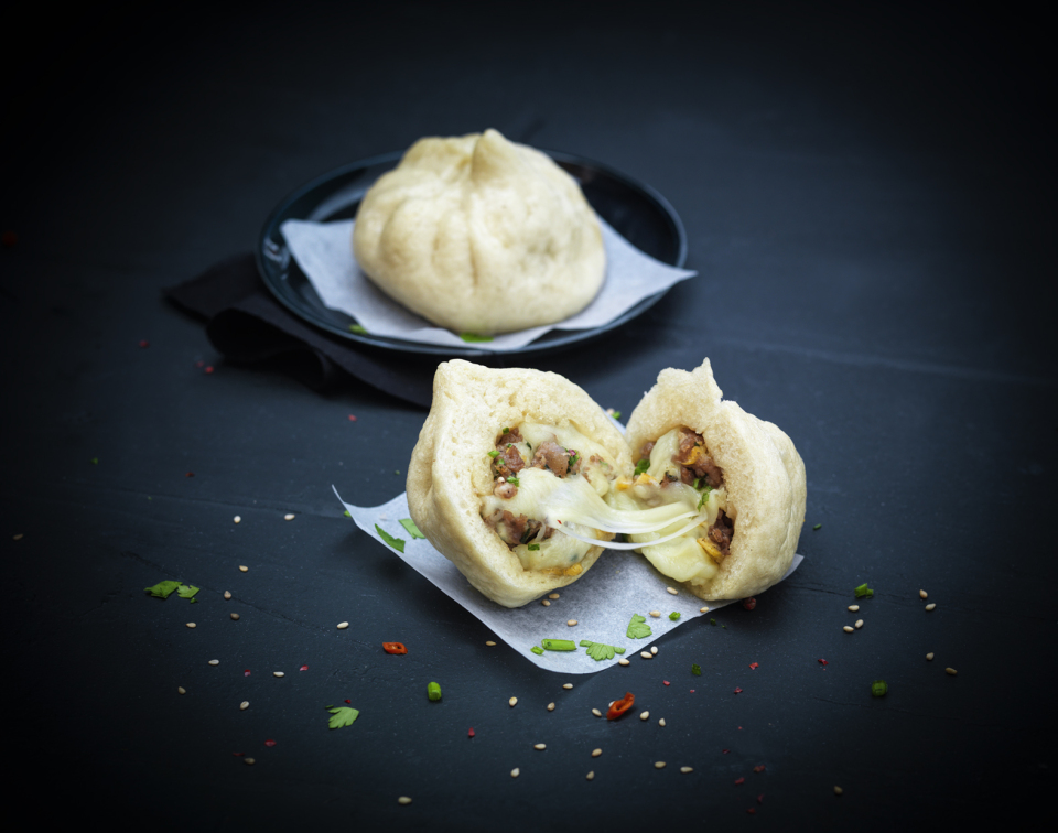 Steamed Baozi filled with seasoned meat and melted Maestrella grated mozzarella 40%, a fusion street food concept delivering consistent melt for professional foodservice.