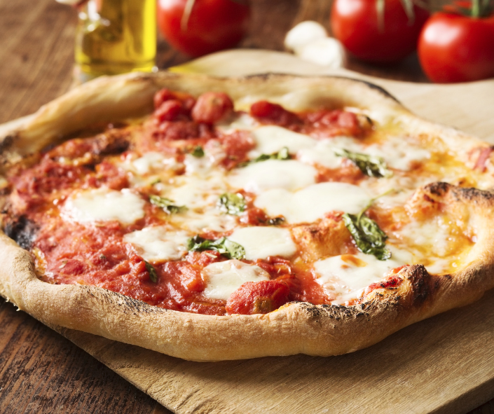 Authentic Neapolitan-style Margherita pizza with charred crust, melted mozzarella, rich tomato sauce and fresh basil on a wooden board, illustrating premium cheese melt performance for professional pizzeria menus.