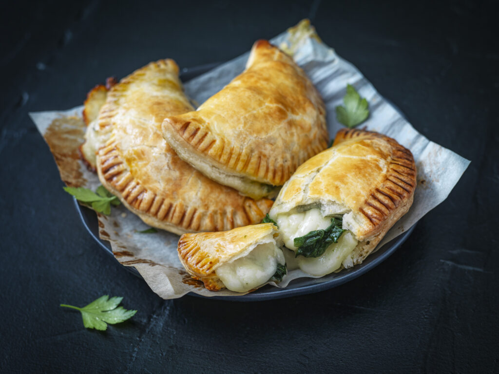 Maestrella Mozzarella melted to perfection inside golden-brown spinach empanadas, showcasing the brand